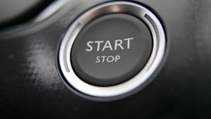 Close-up of a car's keyless ignition button with start and stop options.